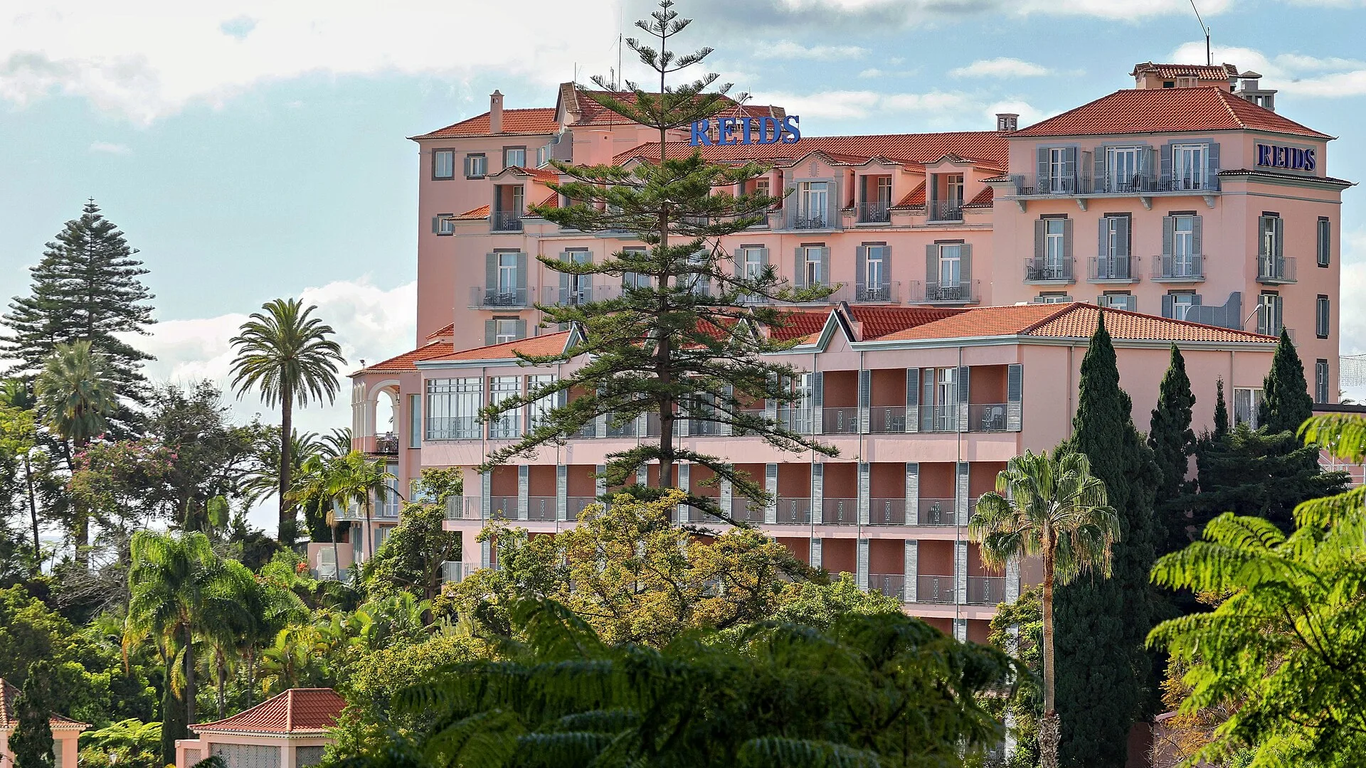 Roze gevel van Belmond Reids Palace boven de Atlantische Oceaan in Funchal Madeira