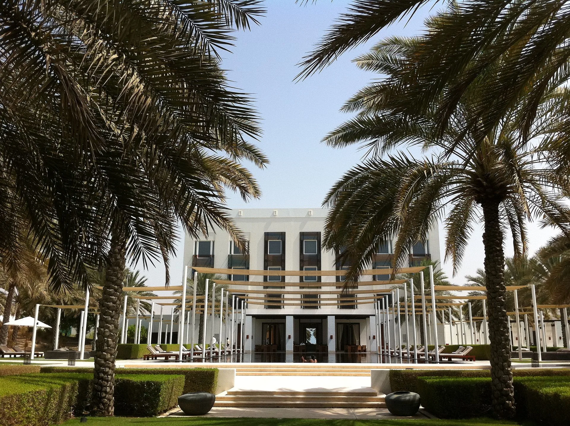 The Chedi Muscat lange smalle zwembad omgeven door witte zuilen